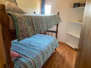 a bed with a quilt on it in a bedroom at Pichidangui, Las Rosas casa 4 personas in Pichidangui