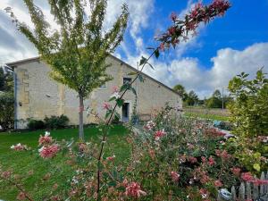 una vecchia casa in pietra con fiori nel cortile di Chambre, sauna, piscine à la campagne a Léguillac de Cercles