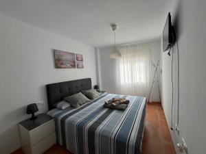 a bedroom with a bed with a striped blanket at Balcón de la Torre del Morche en Torrox Costa in El Morche
