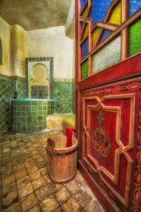 ein Gemälde eines Badezimmers mit einer Badewanne neben einer Tür in der Unterkunft Dar Meziana in Chefchaouen