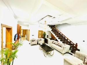 a living room with couches and a staircase at Dream Inn Guest House Islamabad in Islamabad
