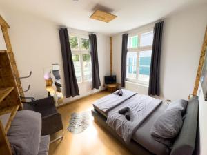 a bedroom with a bed and a couch and windows at #111 - LUX-Flat Lennep - Altstadt - Netflix & Amazon Prime - Felswand in Remscheid