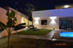 un cortile con una piscina e una casa di notte di El Refugio a Siviglia