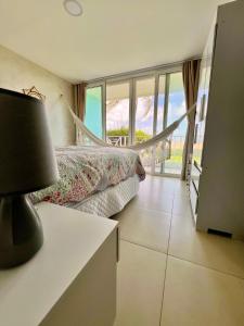 a bedroom with a bed and a table with a lamp at Ocean front privacy and comfort! in Pitangui +10 photos