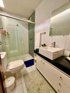 a bathroom with a sink and a toilet and a shower at Ocean front privacy and comfort! in Pitangui
