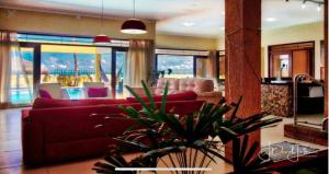 a living room with a red couch and a table at Ocean front privacy and comfort! in Pitangui
