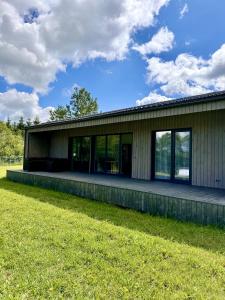 a building with a grass field in front of it at Kaštonų krantas in Antotylʼtse