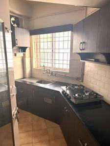 a kitchen with a stove and a sink at Suave 2bhk in Chennai
