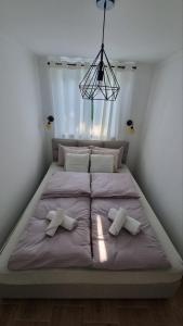 a large bed with two pillows on it in a bedroom at Panonski raj in Palić