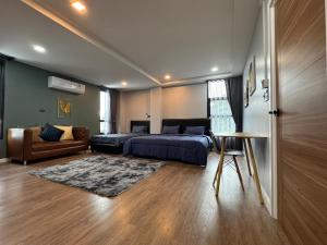 una camera da letto con un letto, un divano e un tavolo di NAP IN NAN Poshtel a Ban Hua Wiang Nua