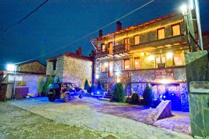 a car parked in front of a building at night at Guesthouse Toitos in Palaios Agios Athanasios