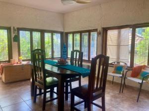 a dining room with a table and chairs and windows at Rural cotage and sandy bay in Tela