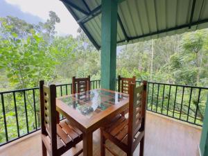 a porch with a table and chairs on a balcony at Ananda Rest-Ella in Ella