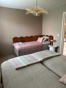 ein Schlafzimmer mit zwei Betten und einem Kronleuchter in der Unterkunft Casa Rantala, cozy living with family and friends in Seinäjoki