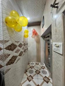 Un baño con globos amarillos en la pared. en Pakhi Residency, en Vrindāvan