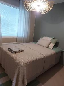 ein Schlafzimmer mit einem Bett mit einer Lampe in der Unterkunft Casa Rantala, cozy living with family and friends in Seinäjoki
