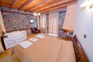 uma casa de banho com uma cama grande e uma banheira em Guesthouse Toitos em Palaios Agios Athanasios