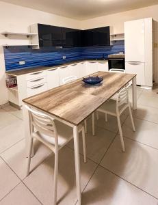 una cucina con un tavolo di legno e due sedie di St Pauls Bay 2 bedrooms a San Pawl il-Baħar
