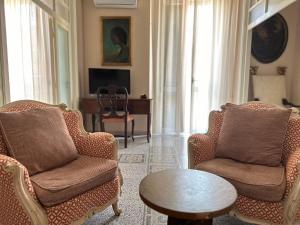 un soggiorno con due sedie e un tavolo di Luxury Suite Vitruvio 55 a Formia