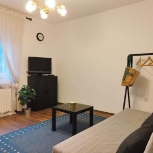 Una sala de estar con una cama y un televisor. en Apartments Miss Katy, en Zagreb