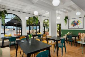a restaurant with tables and chairs and windows at Neighbourgood Hill in Cape Town