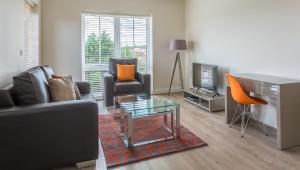 a living room with a couch and a table at House of Fisher - Athena Court in Maidenhead