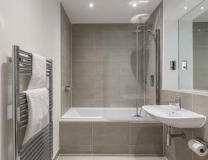 a bathroom with a tub and a sink and a shower at House of Fisher - Athena Court in Maidenhead