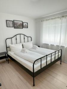 a bedroom with a black bed with white pillows at Appartment Peerless 2 min zum Europa Park in Rust