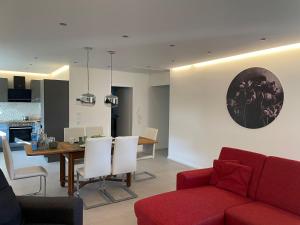 a living room with a red couch and a table at Panoramaapartment Wine & Castle in Bernkastel-Kues