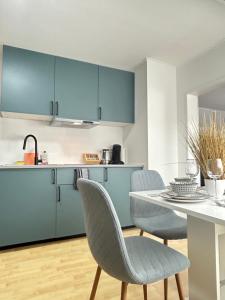 a kitchen with blue cabinets and a table with chairs at Fewo ONE - by Europapark in Rust
