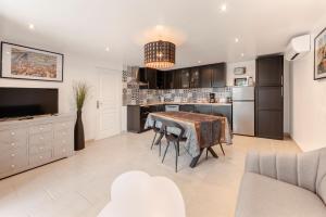 a kitchen with a table and a dining room at Le Mas des Oliviers in Gréoux-les-Bains