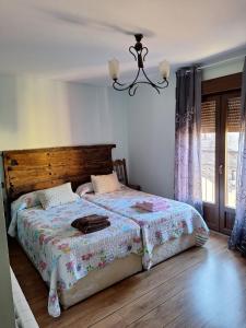 a bedroom with a bed and a chandelier at Casa rural El Balcón del Tajuña in Valfermoso de Tajuña