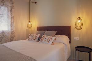 a bedroom with a large white bed with two pillows at Apartamento Urbano Granada in Granada +25 photos