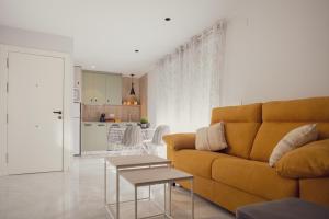 a living room with a yellow couch and a table at Apartamento Urbano Granada in Granada