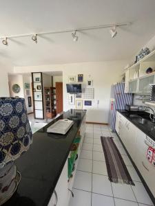 Una cocina con encimera negra en una habitación. en Cond Solar Lagoa dos Passaros, en Praia do Forte