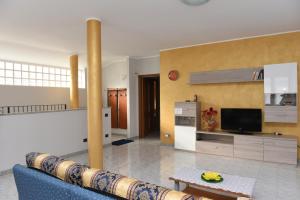a living room with a blue couch and a tv at Casa Dante in Romano di Lombardia
