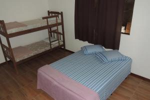 a bed in a room with two bunk beds at Chácara Recanto dos Pássaros in São Thomé das Letras