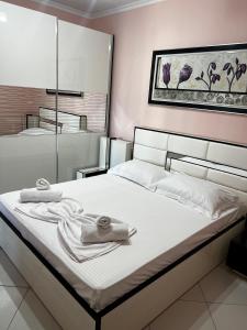 a bedroom with a white bed with towels on it at AMY'S LUXURY APPARTMENT in Shkodër
