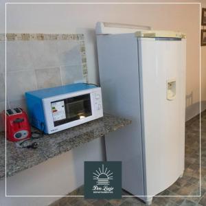 a microwave on a counter next to a refrigerator at Don Lucio Departamentos in Carhué