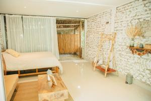 1 dormitorio con 1 cama en una habitación con una pared de ladrillo en Cabañas Tranquilidad Total, en Gaira
