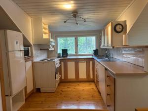 Una cocina con electrodomésticos blancos y suelo de madera. en Cosy apartment in two floors in Skutnabba Pietarsaari, en Skutnabba