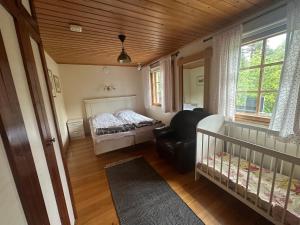 1 dormitorio con cuna, cama y sofá en Cosy apartment in two floors in Skutnabba Pietarsaari, en Skutnabba