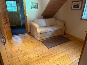 sala de estar con sofá y suelo de madera en Cosy apartment in two floors in Skutnabba Pietarsaari, en Skutnabba