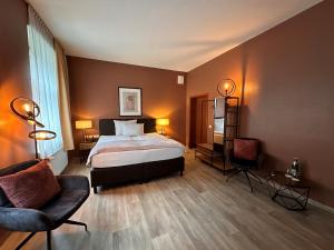a bedroom with a bed and a couch and a chair at Hotel Bentheimer Hof in Bad Bentheim