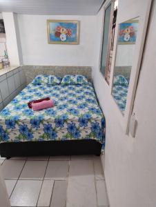 a bedroom with a bed with blue flowers on it at Kitnet aconchegante in Olinda