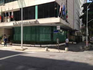 un edificio en una calle con banderas delante en Rio Design Copacabana Hotel, en Río de Janeiro