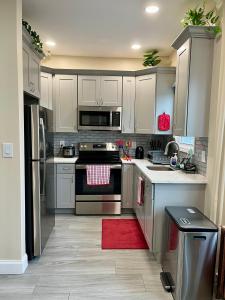a kitchen with white cabinets and a red rug at New York City Apartment Near Free Ferry Boat! in Stapleton