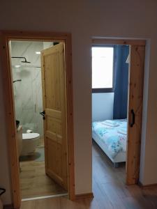 a bathroom with a door open to a bedroom with a bed at Pine House Novalja in Gajac +12 photos
