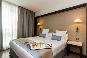 a hotel room with a bed, desk, and nightstand at LCB Hotel Fuenlabrada in Fuenlabrada