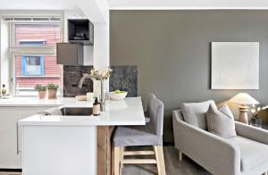 トロンハイムにあるKoselig leilighet ved Solsidenのキッチン、リビングルーム(シンク、ソファ付)